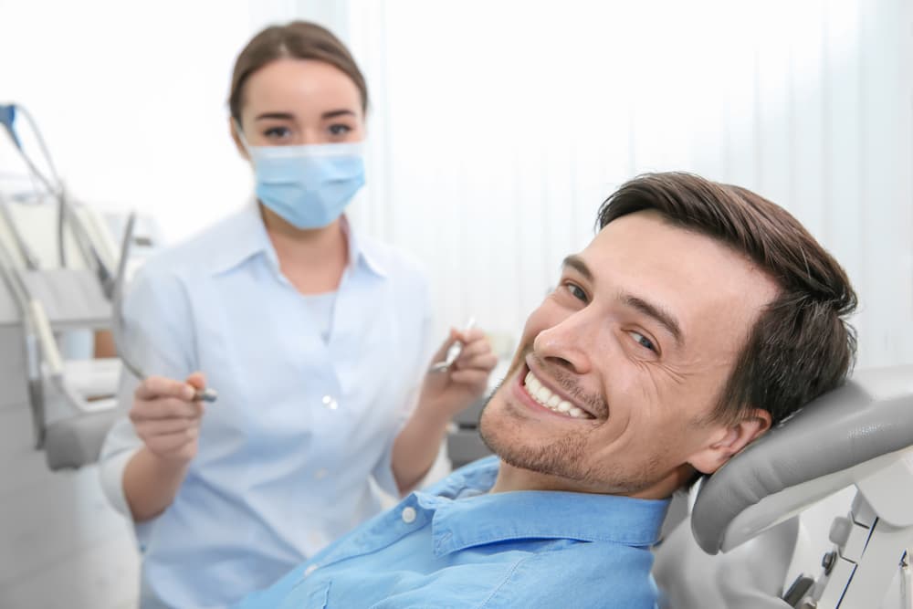 Patient smiling with dentist in clinic.
