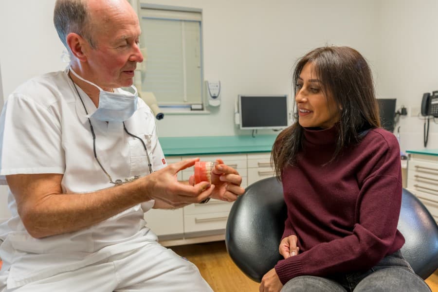 Dr Patrick Kennedy with patient explaining dental implants